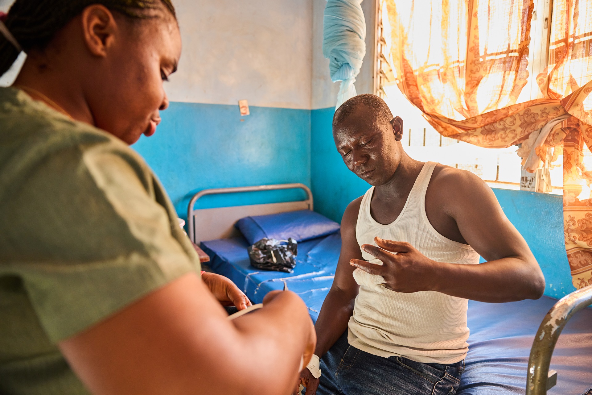 A nurse and a patient admitted for skin-related NTDs in a district health center in sub-Saharan Africa